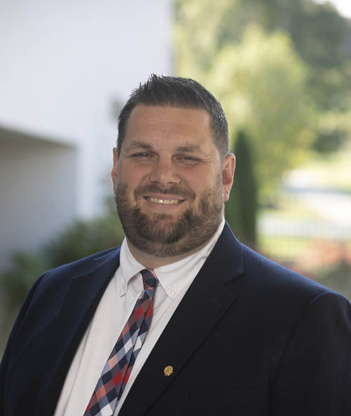 Man in a blue suit smiles